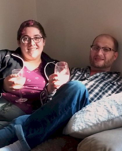 two people with drinks on a beanbag chair