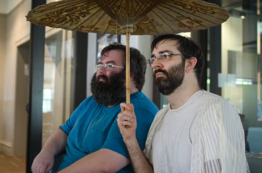 two people sitting together under a parasol